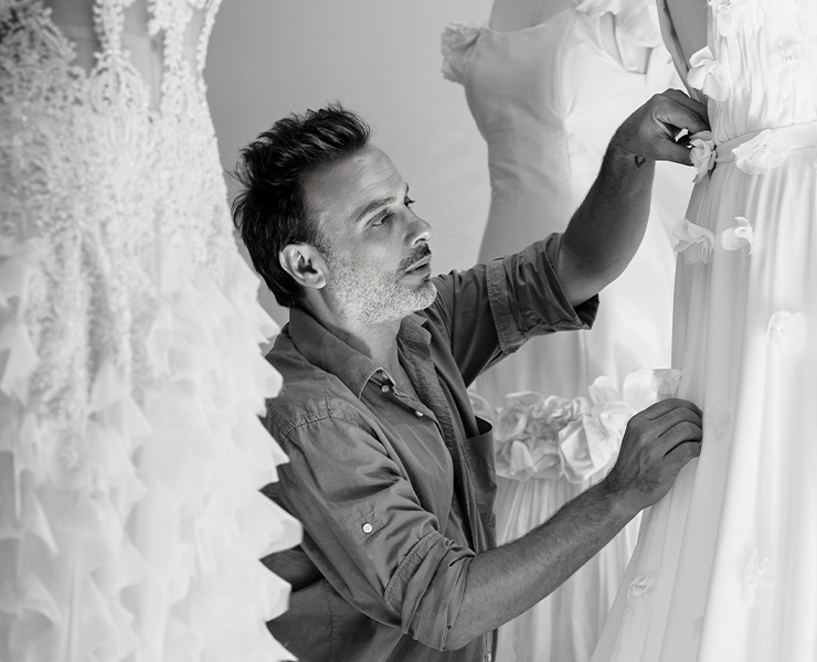 Vol Fioravante finalizando à mão os detalhes de um vestido de noiva